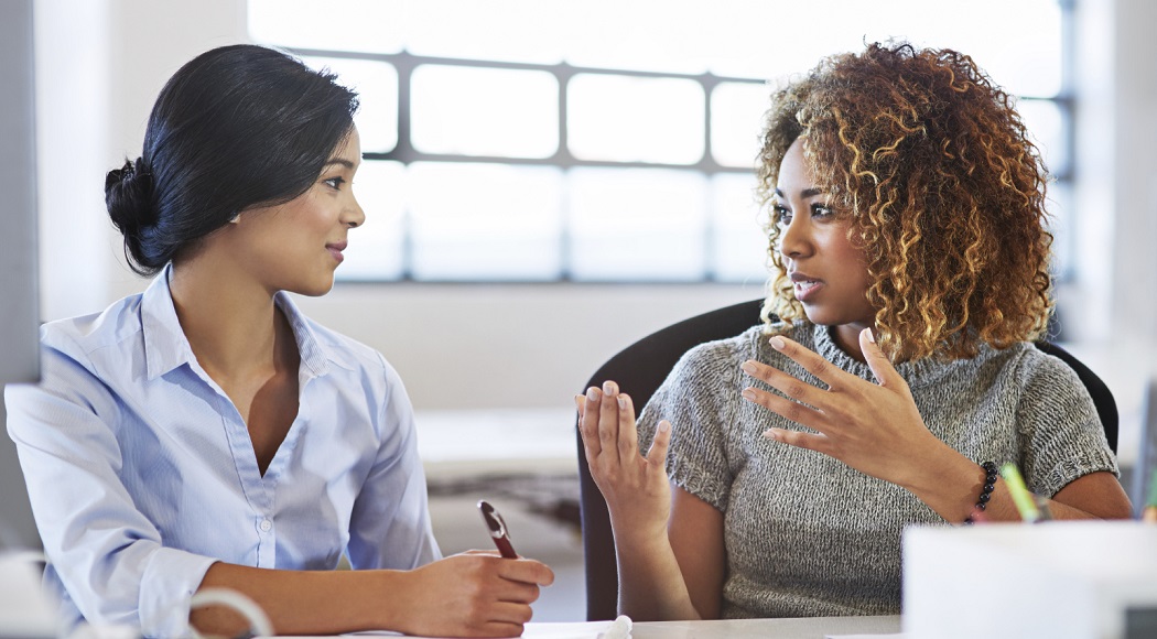 Two businesswomen discuss matters one-on-one, up close